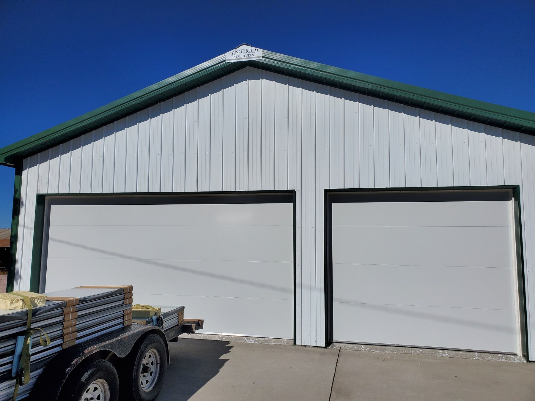 White flush panel shop doors framed with green trim